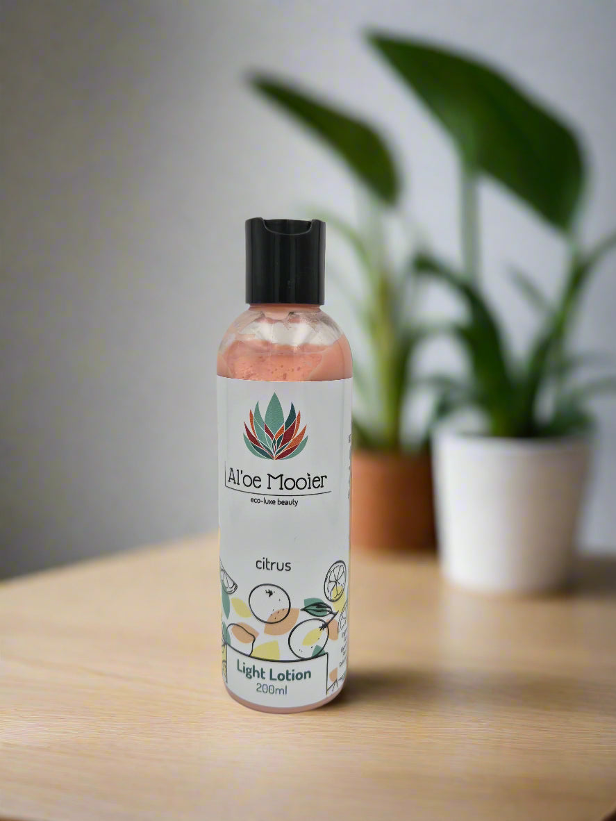 Aloe Mooler citrus light lotion bottle on a wooden surface with a plant in the background