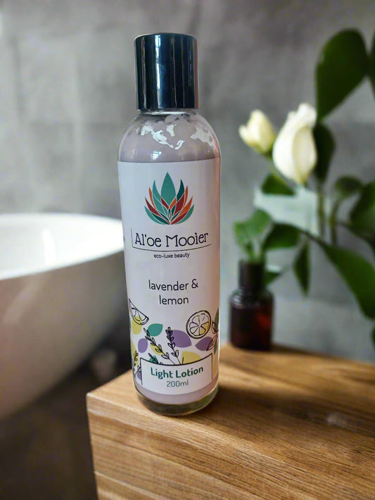 A bottle of Aloe Mooler lavender and lemon light lotion on a marble surface with a blurred background.